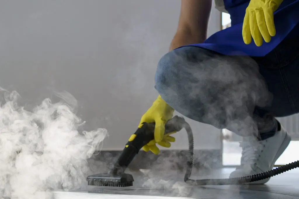 Person verwendet Dampfreiniger zur Grundreinigung in einem Büro. Grundreinigung bei Erdan Glas- und Gebäudereinigung