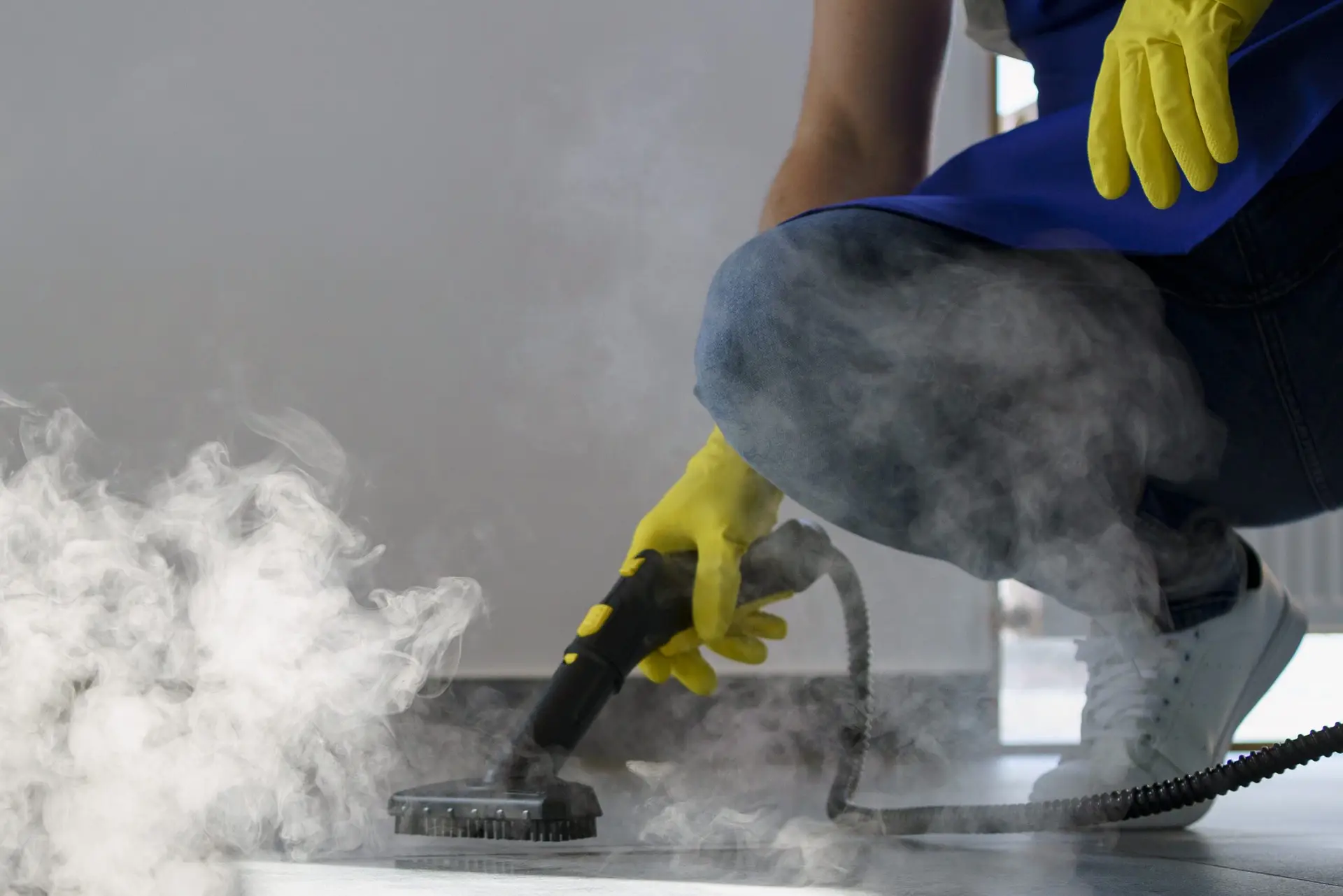 Person verwendet Dampfreiniger zur Grundreinigung in einem Büro. Grundreinigung bei Erdan Glas- und Gebäudereinigung